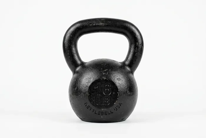 Quel poids pour kettlebell choisir selon votre niveau en 2026 Kettlebell noir sur fond blanc
